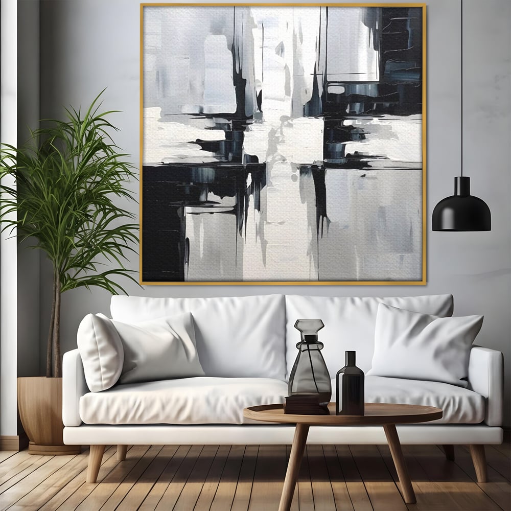 Tablou canvas cu pictura abstracta alb-negru, in rama de aluminiu auriu, pe perete intr-un living
