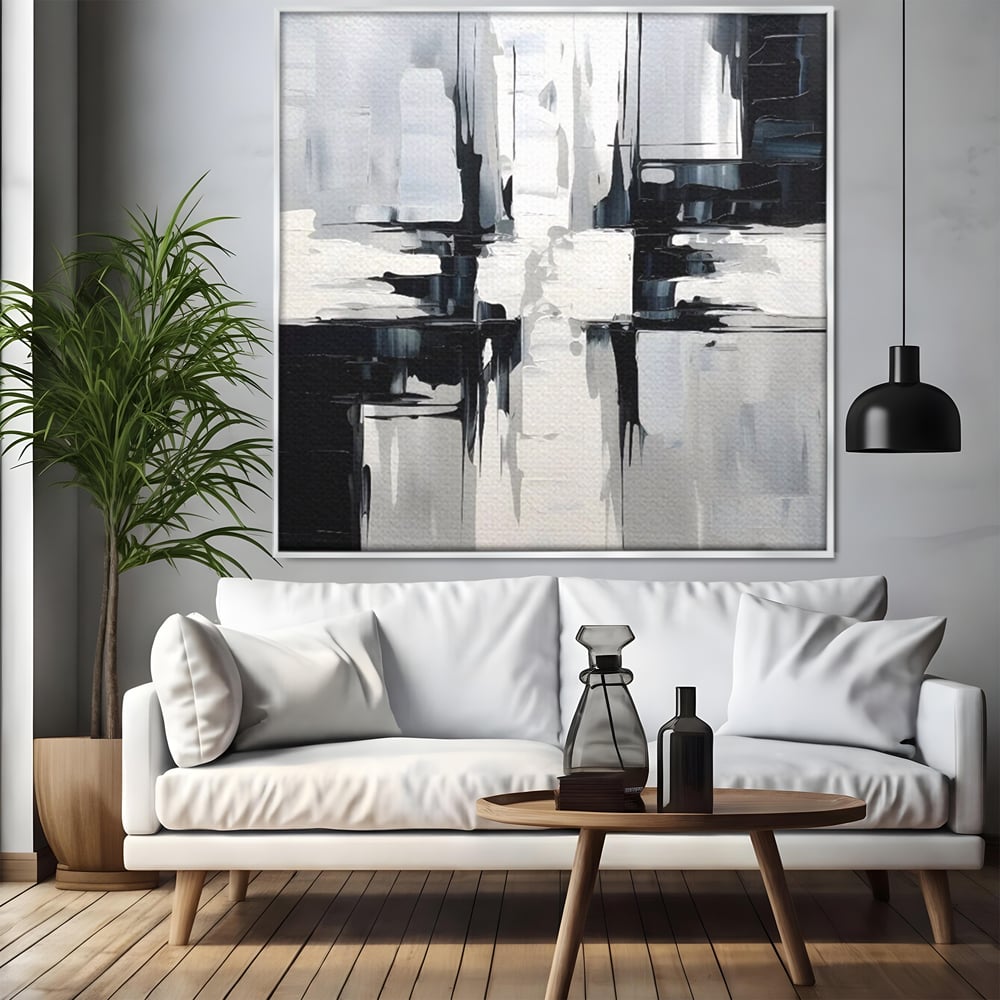 Tablou canvas cu pictura abstracta alb-negru, in rama de aluminiu argintiu, pe perete intr-un living