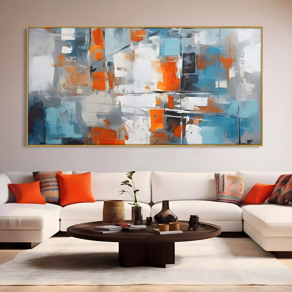 Tablou canvas cu pictura abstracta cu blocuri portocalii si albastre, in rama de aluminiu auriu, pe perete intr-un living