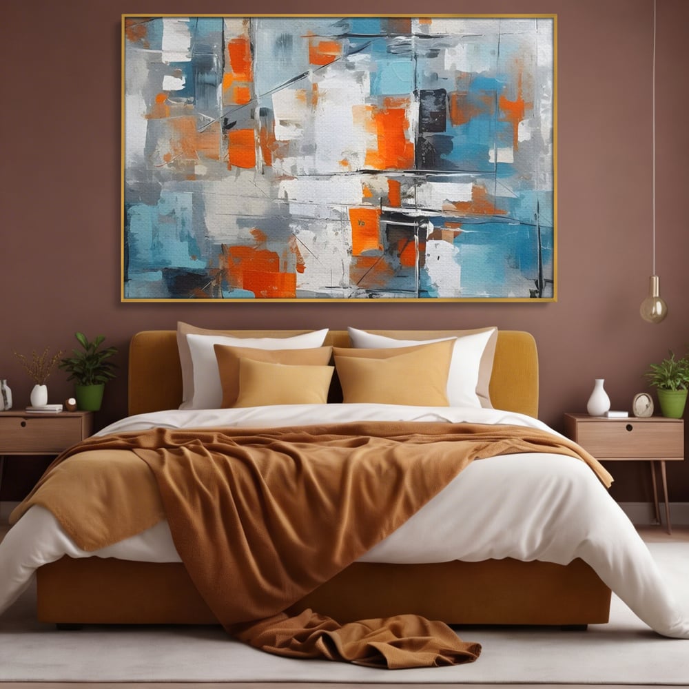 Tablou canvas cu pictura abstracta cu blocuri portocalii si albastre, in rama de aluminiu auriu, pe perete intr-un dormitor