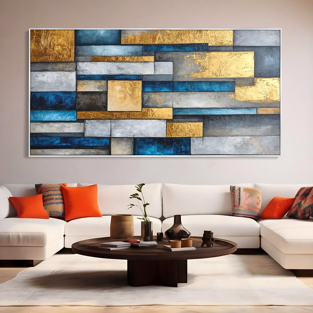 Tablou canvas cu pictura abstracta cu forme geometrice aurii, in rama de aluminiu argintiu, pe perete intr-un living