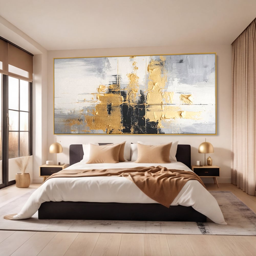 Tablou canvas cu pictura abstracta cu auriu si negru, in rama de aluminiu auriu, pe perete intr-un dormitor