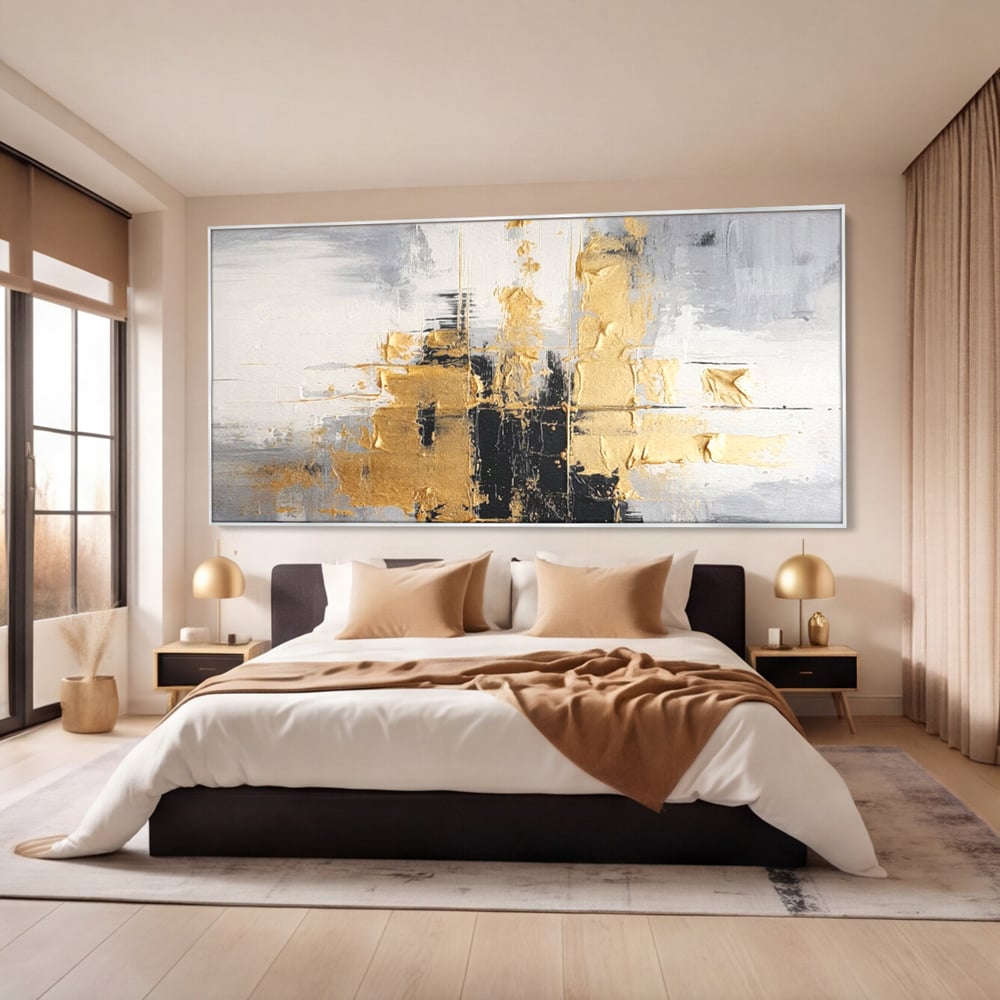 Tablou canvas cu pictura abstracta cu auriu si negru, in rama de aluminiu argintiu, pe perete intr-un dormitor