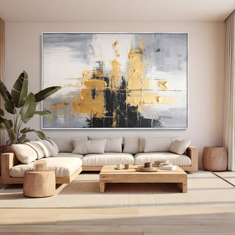 Tablou canvas cu pictura abstracta cu auriu si negru, in rama de aluminiu argintiu, pe perete intr-un living