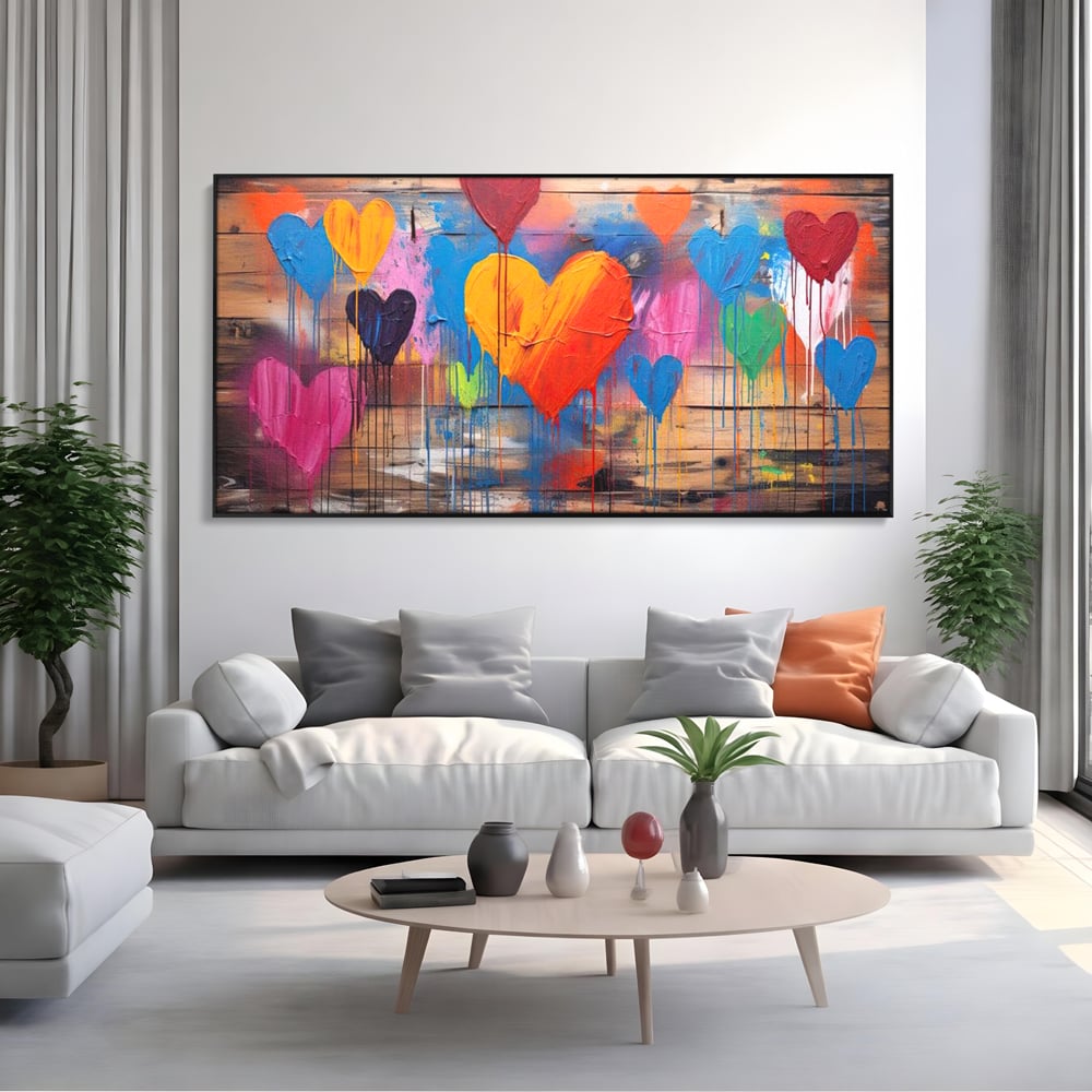 Tablou canvas cu tablou cu inimi colorate pe scanduri, in rama de aluminiu negru, pe perete intr-un living
