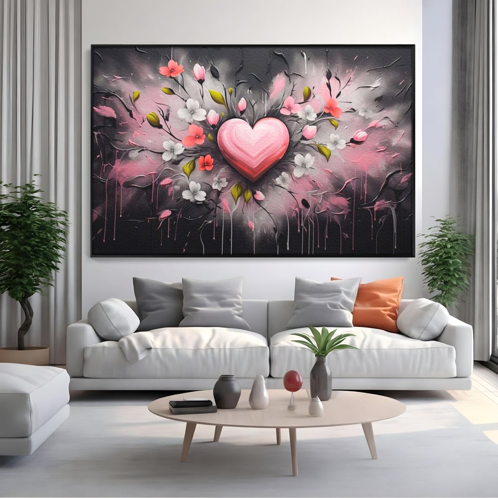 Tablou canvas cu tablou canvas cu inima roz si flori, in rama de aluminiu negru, pe perete intr-un living