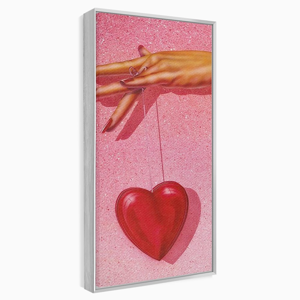 Tablou canvas cu ilustratie cu mana care tine o inima rosie, in rama de aluminiu argintiu