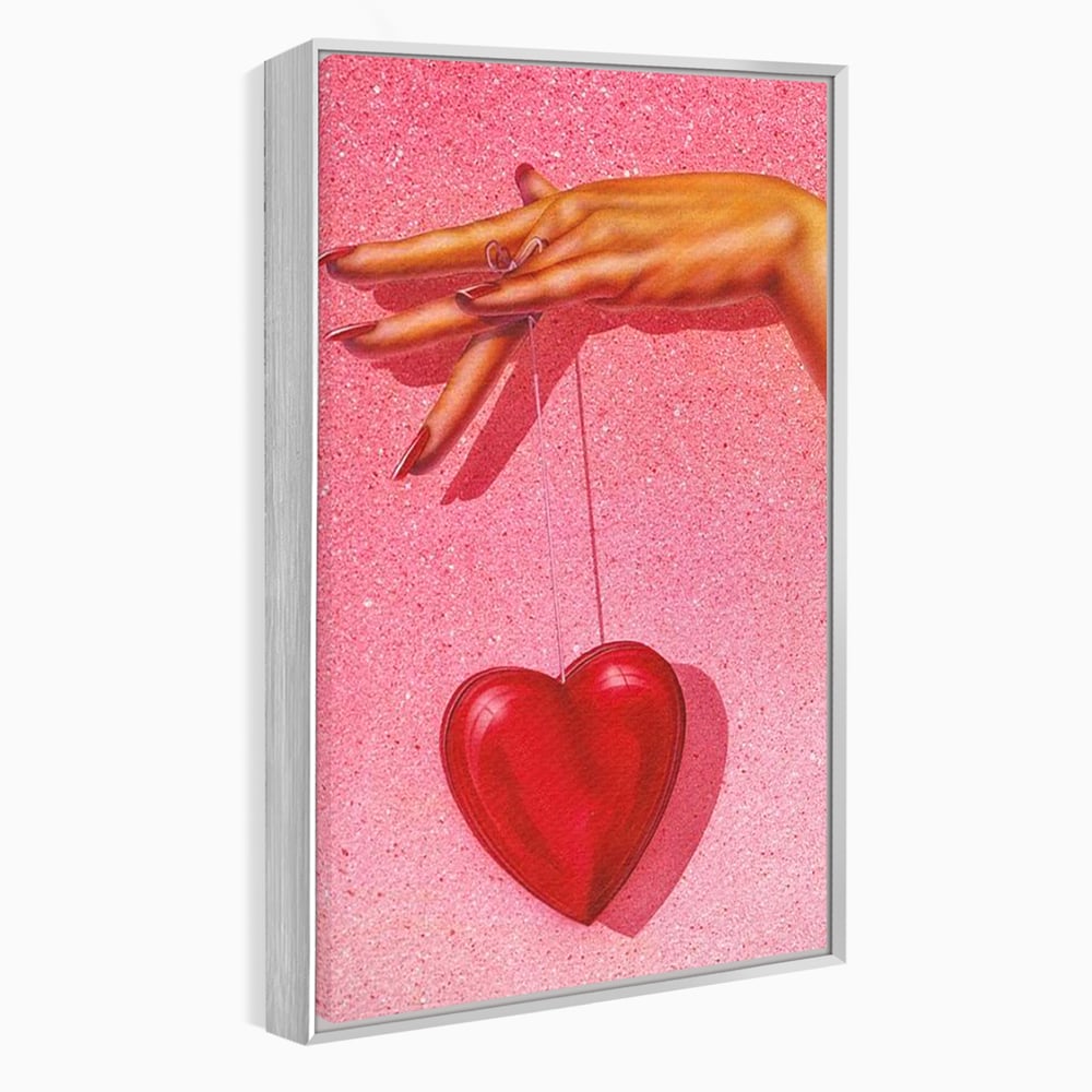 Tablou canvas cu ilustratie cu mana care tine o inima rosie, in rama de aluminiu argintiu