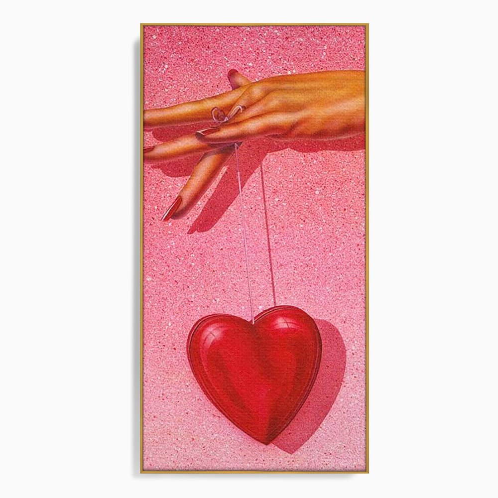 Tablou canvas cu ilustratie cu mana care tine o inima rosie, in rama de aluminiu auriu