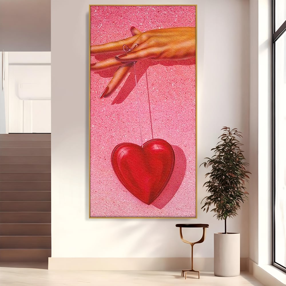 Tablou canvas cu ilustratie cu mana care tine o inima rosie, in rama de aluminiu auriu
