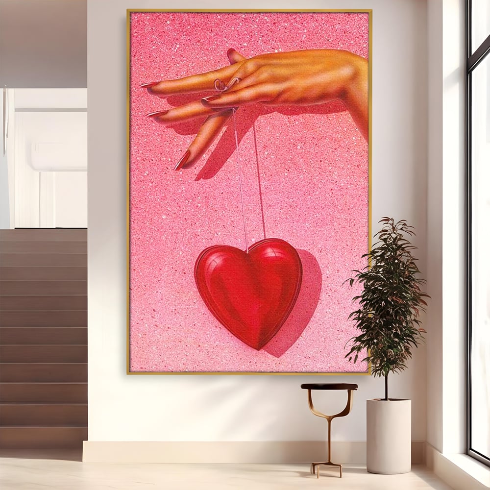 Tablou canvas cu ilustratie cu mana care tine o inima rosie, in rama de aluminiu auriu