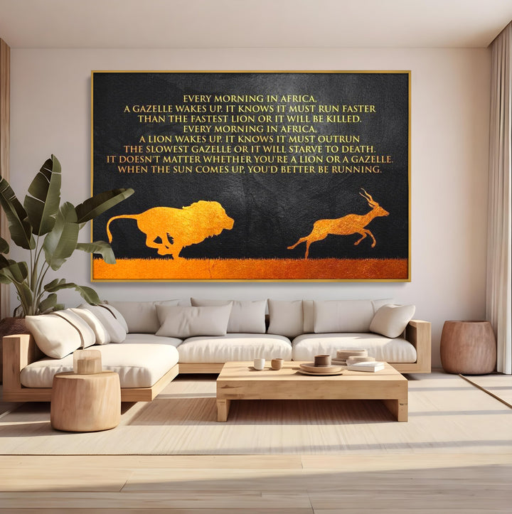 Tablou canvas cu tablou motivational cu leu si gazela, in rama de aluminiu auriu, pe perete intr-un living