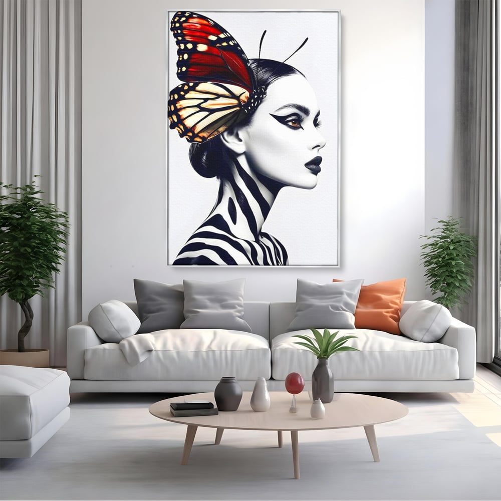 Tablou canvas cu tablou canvas cu femeie si aripa de fluture, in rama de aluminiu argintiu, pe perete intr-un living