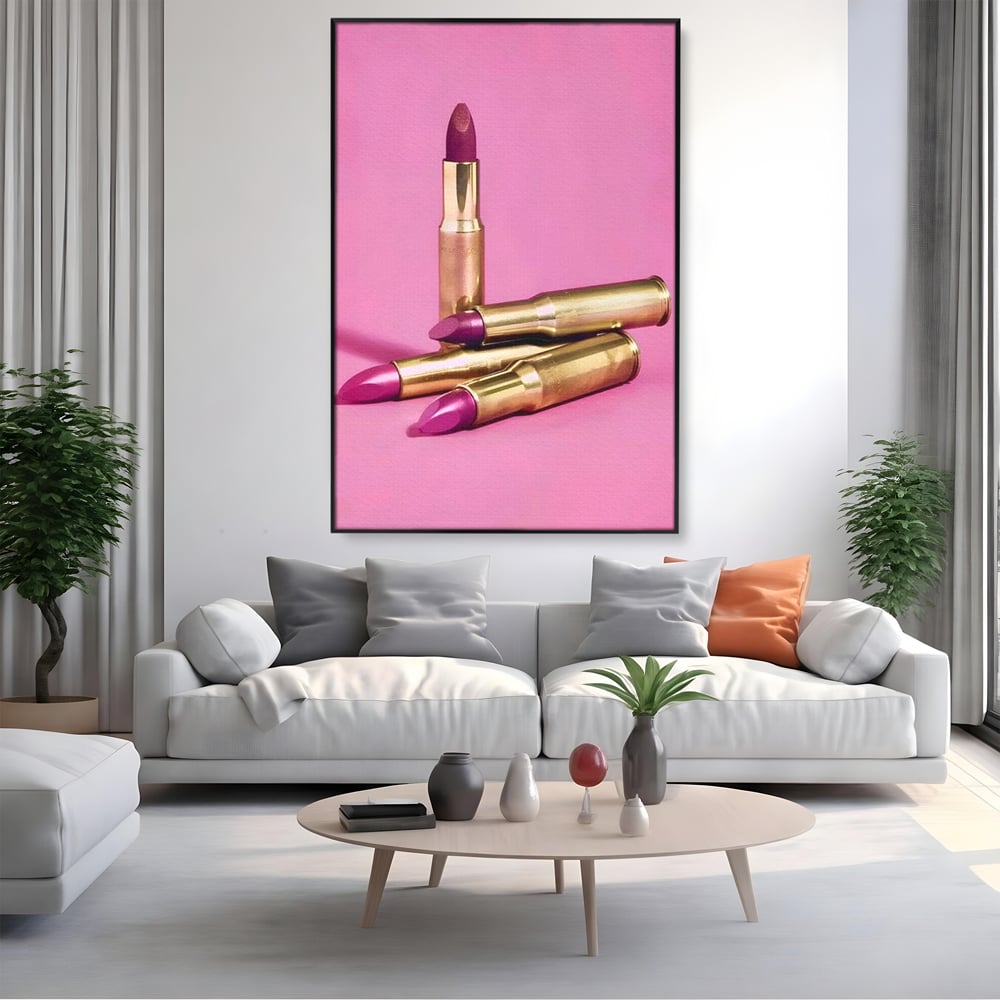 Tablou canvas cu tablou canvas cu rujuri in forme de cartuse pe fond roz, in rama de aluminiu negru, pe perete intr-un living