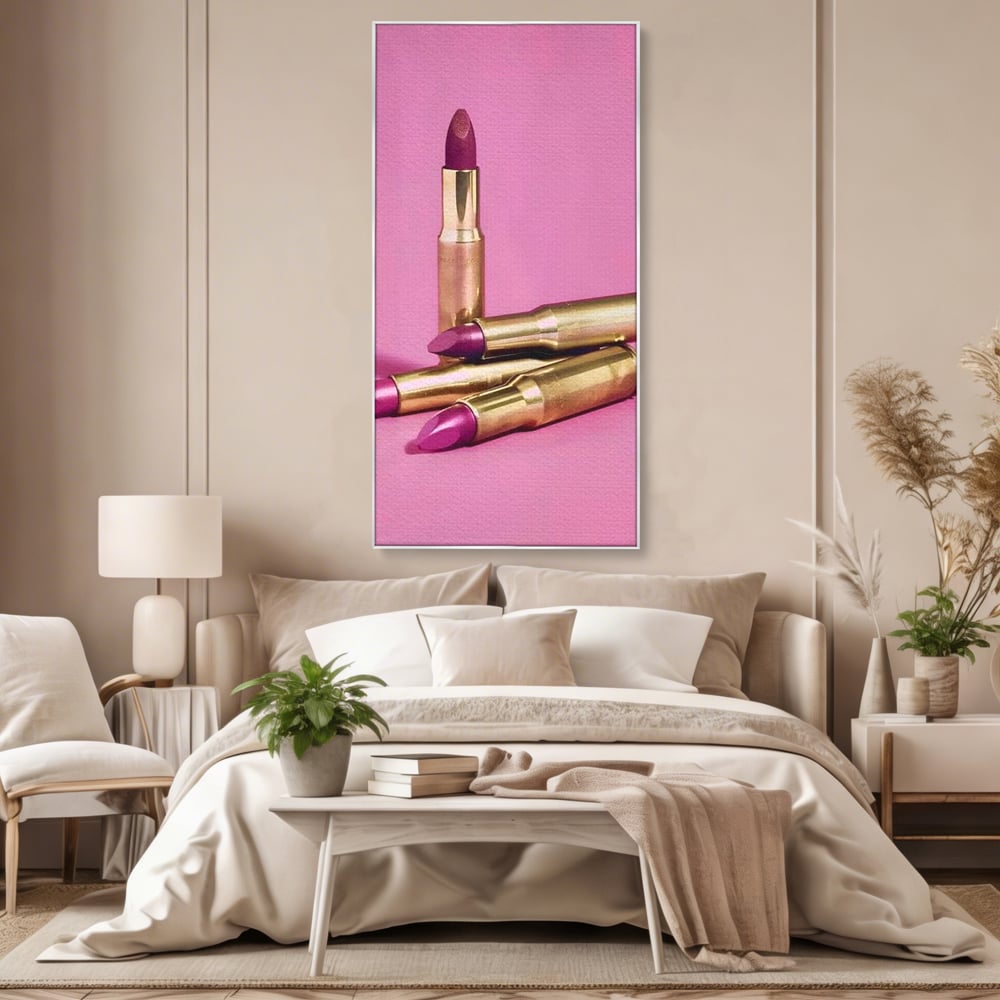 Tablou canvas cu tablou canvas cu rujuri in forme de cartuse pe fond roz, in rama de aluminiu argintiu, pe perete intr-un dormitor