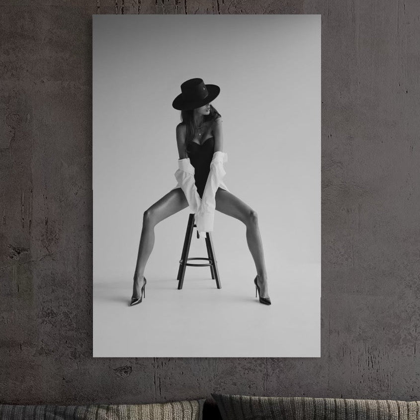 tablou canvas cu o femeie cu palarie si camasa alba intr-o ipostaza sexy, pe un scaun, intr-un cadru alb si negru
