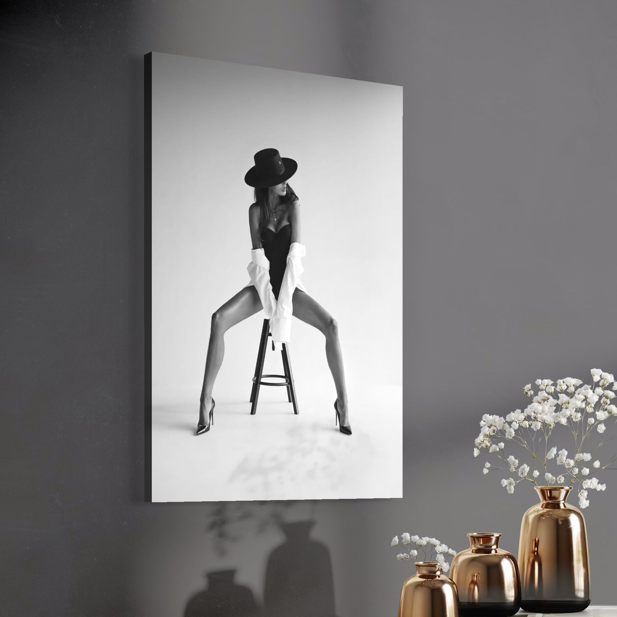 tablou canvas cu o femeie cu palarie si camasa alba intr-o ipostaza sexy, pe un scaun, intr-un cadru alb si negru