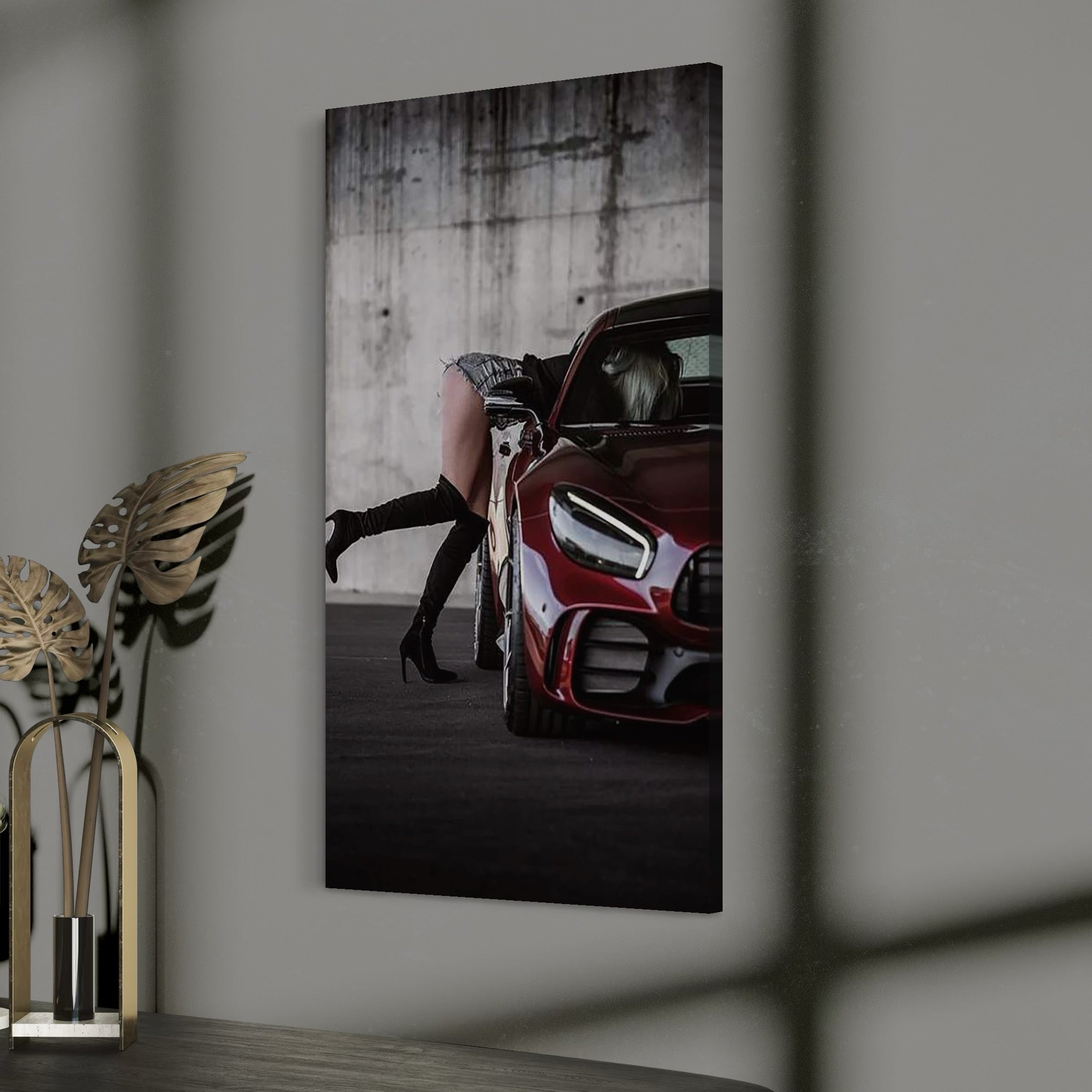 tablou canvas cu o femeie cu cizme cu toc, surprinsa intr-o masina rosie intr-o ipostaza sexy, pe fundal in stil urban