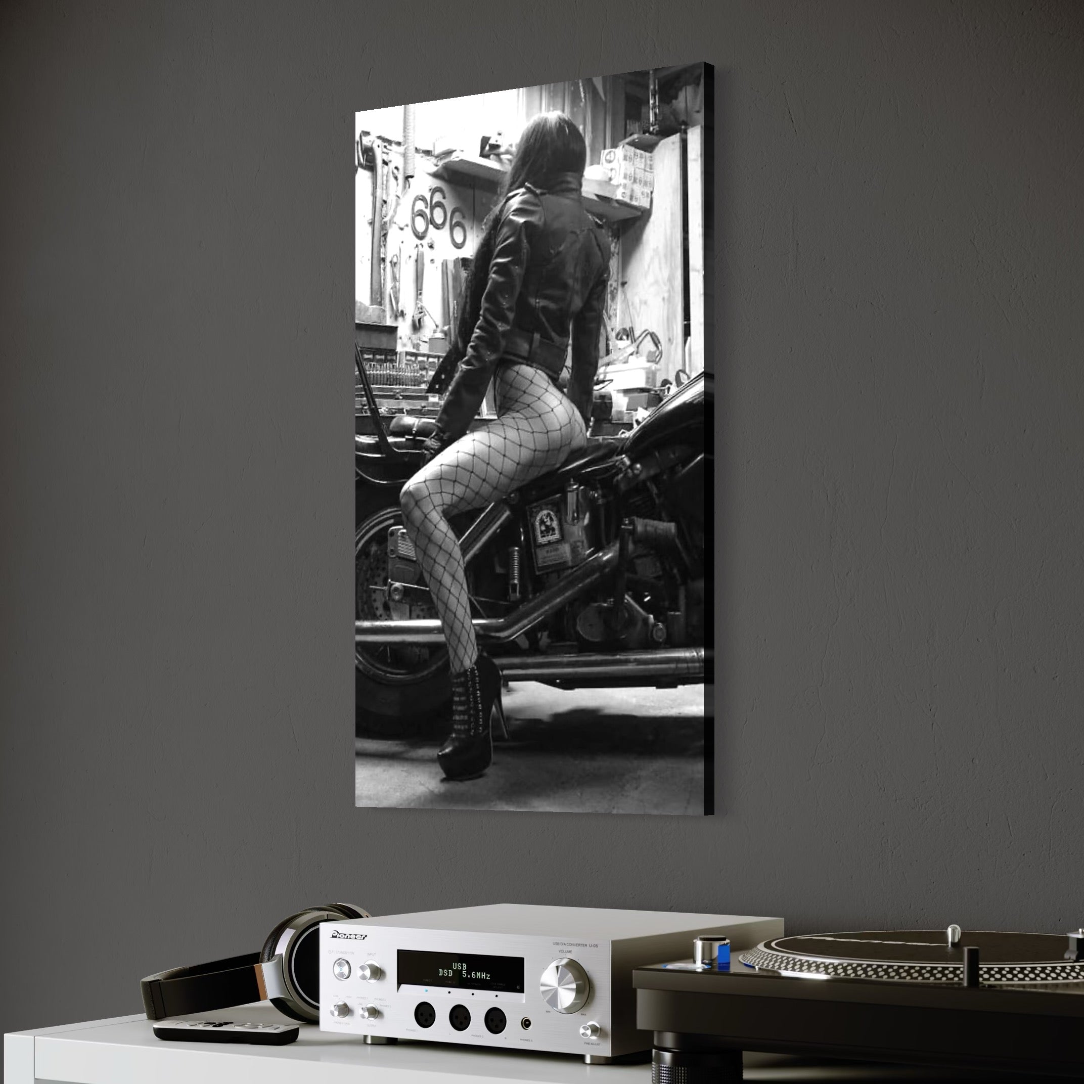 tablou canvas cu o femeie cu dresuri tip plasa pe o motocicleta , intr-un garaj redat in nuante de alb si negru