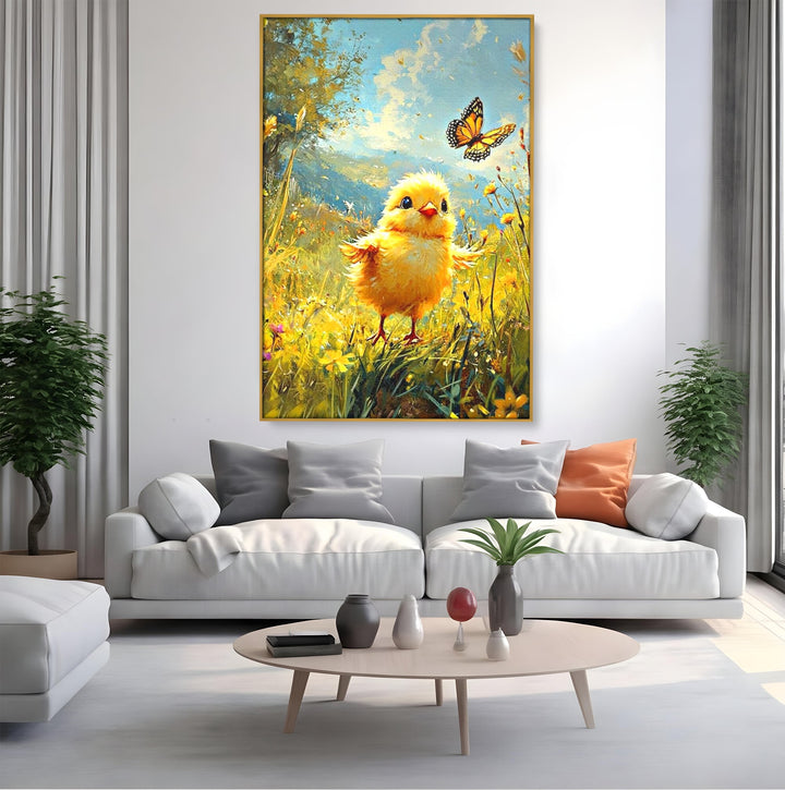 Tablou canvas cu tablou canvas cu pui de pasare si fluture, in rama de aluminiu auriu, pe perete intr-un living