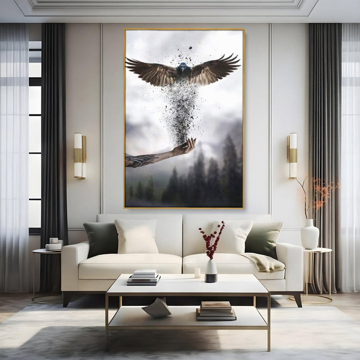 Tablou canvas cu tablou canvas cu pasare si mana din cenusa, in rama de aluminiu auriu, pe perete intr-un living