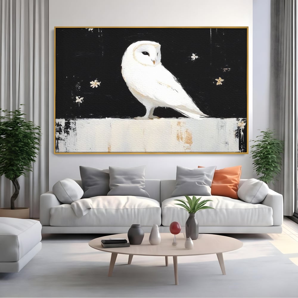 Tablou canvas cu tablou canvas cu bufnita alba, in rama de aluminiu auriu, pe perete intr-un living