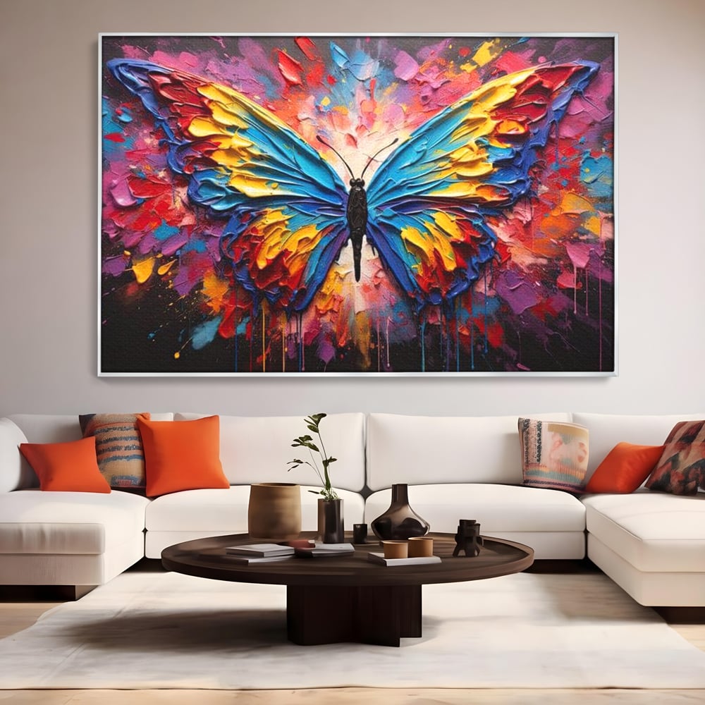 Tablou canvas cu pictura cu fluture colorat, in rama de aluminiu argintiu, pe perete intr-un living