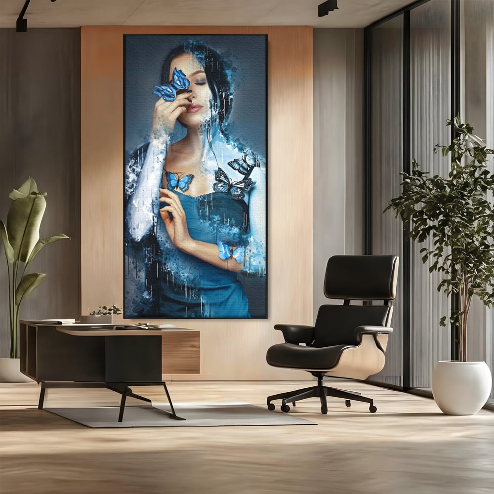 Tablou canvas cu portret feminin cu fluturi albastri, in rama de aluminiu negru, pe perete intr-un birou