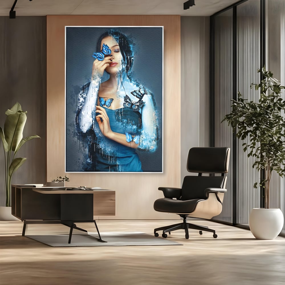 Tablou canvas cu portret feminin cu fluturi albastri, in rama de aluminiu argintiu, pe perete intr-un birou