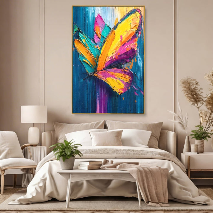 Tablou canvas cu pictura canvas cu fluture colorat, in rama de aluminiu auriu, pe perete intr-un dormitor