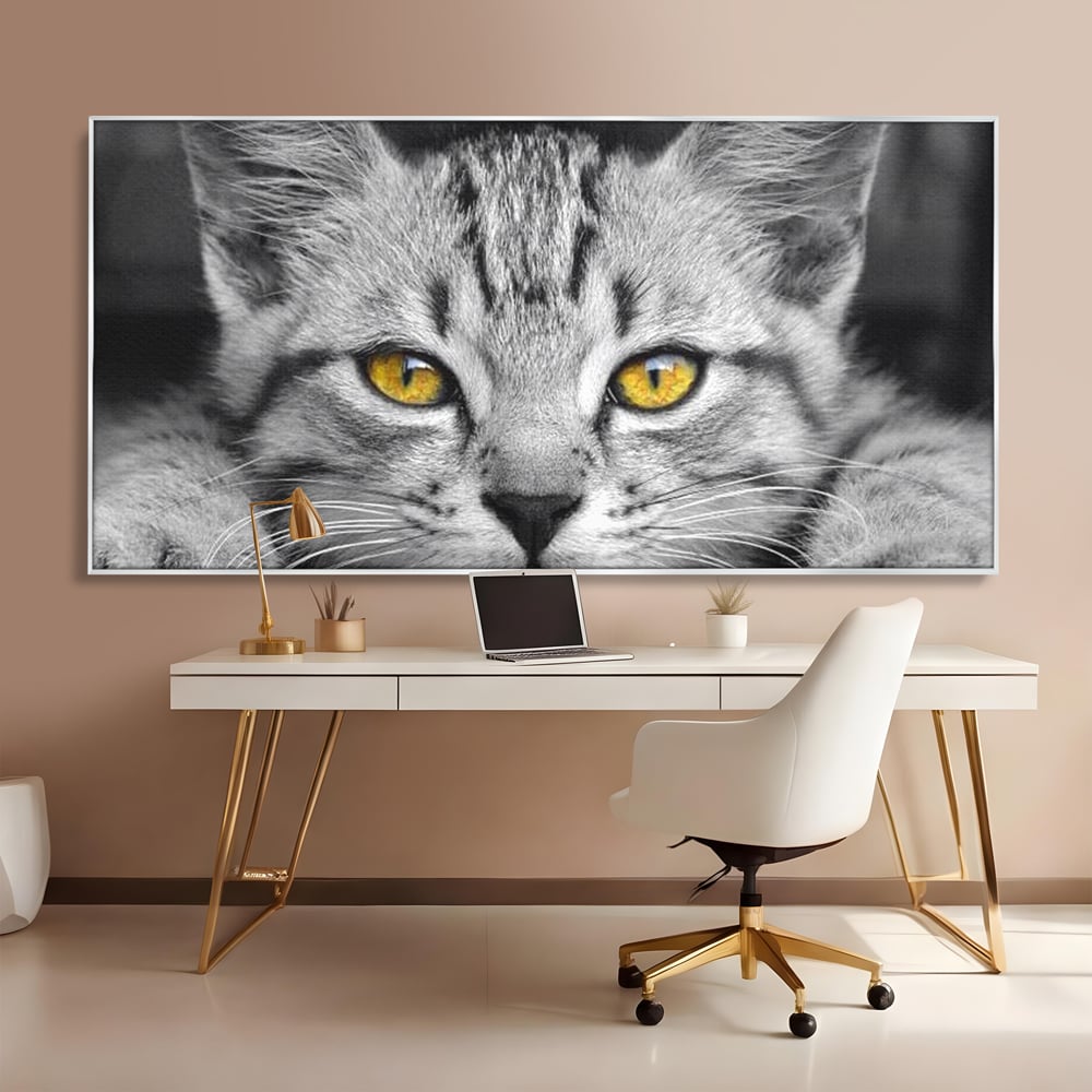 Tablou canvas cu tablou canvas cu o pisica alb-negru si ochi galbeni, in rama de aluminiu argintiu, pe perete intr-un birou