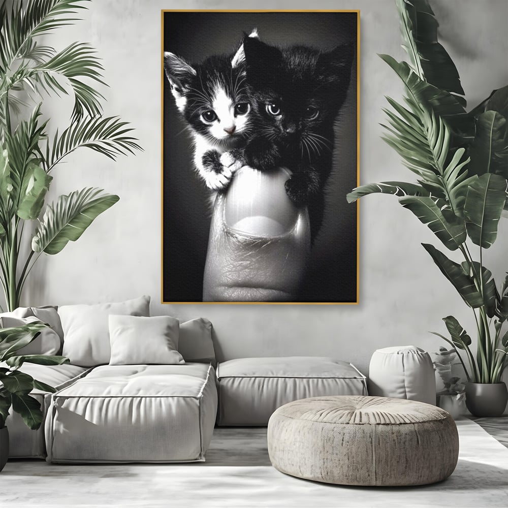 Tablou canvas cu tablou canvas cu doi pisoi mici agatati de un deget, in rama de aluminiu auriu, pe perete intr-un living