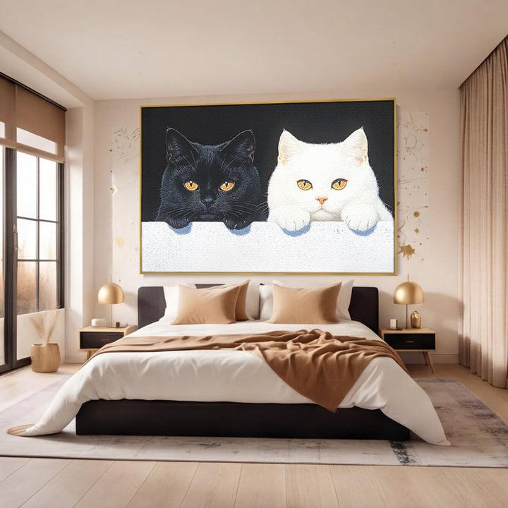 Tablou canvas cu tablou canvas cu pisici alb si negru, in rama de aluminiu auriu, pe perete intr-un dormitor