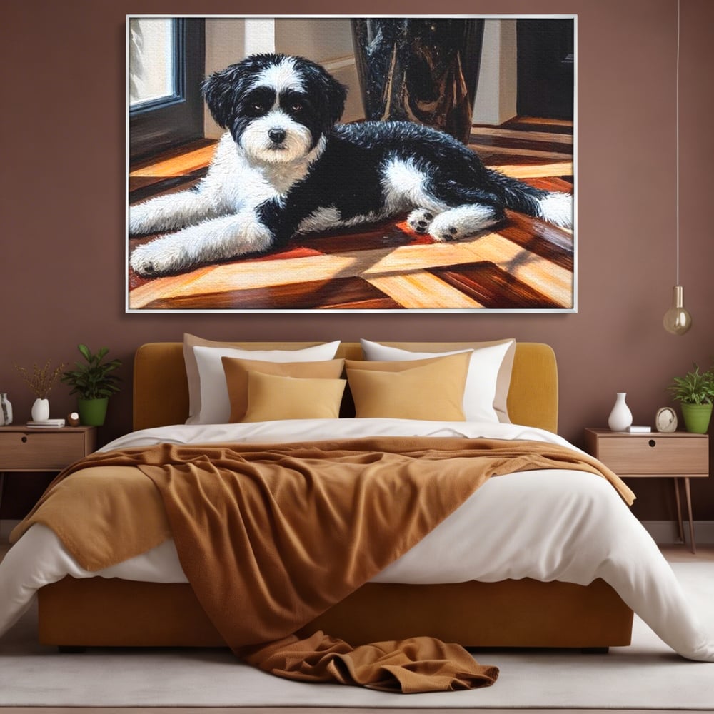 Tablou canvas cu tablou canvas cu catel negru cu alb, in rama de aluminiu argintiu, pe perete intr-un dormitor