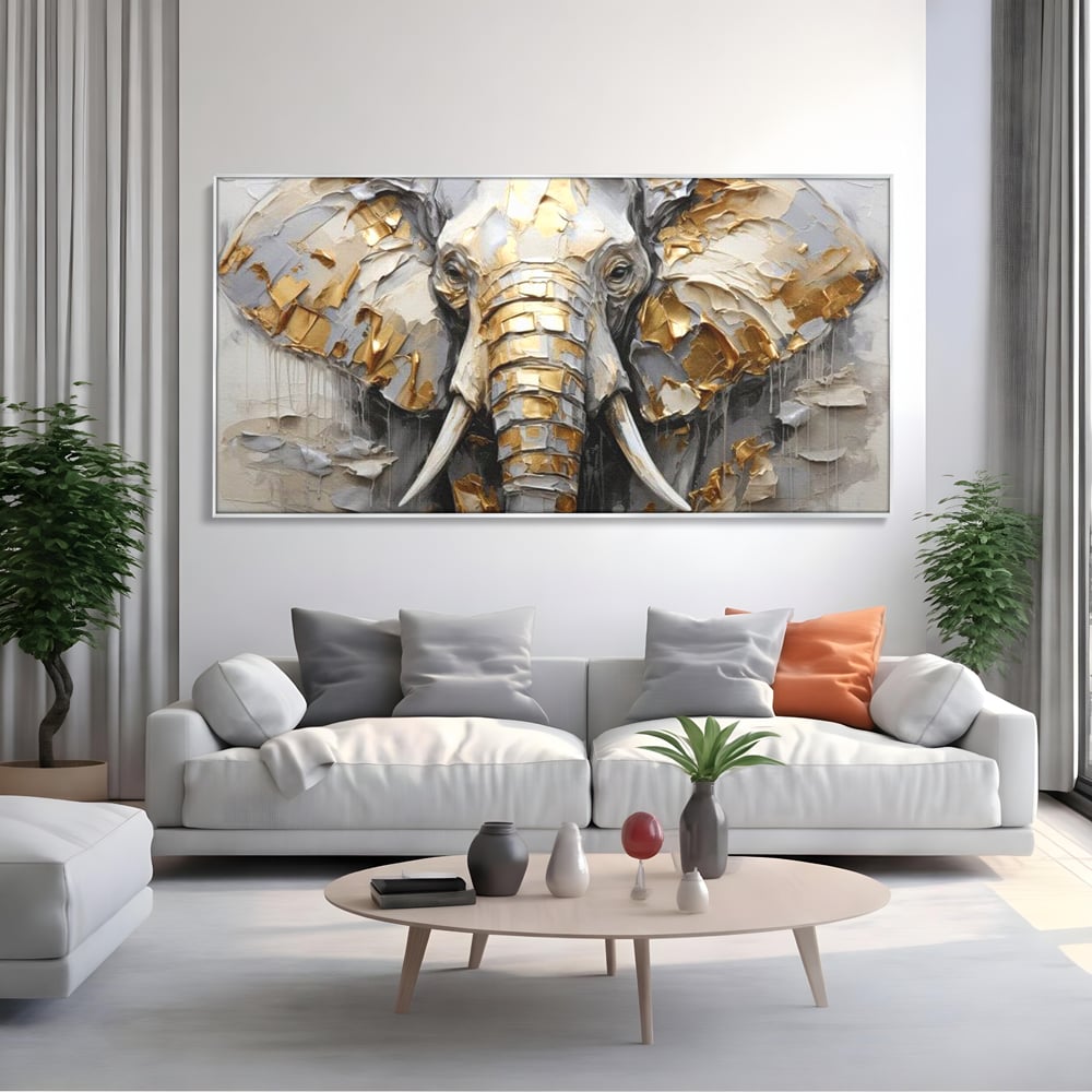 Tablou canvas cu tablou canvas cu cap de elefant in relief si insertii aurii, in rama de aluminiu argintiu, pe perete intr-un living