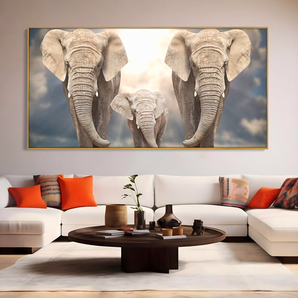 Tablou canvas cu tablou canvas cu trei elefanti, in rama de aluminiu auriu, pe perete intr-un living