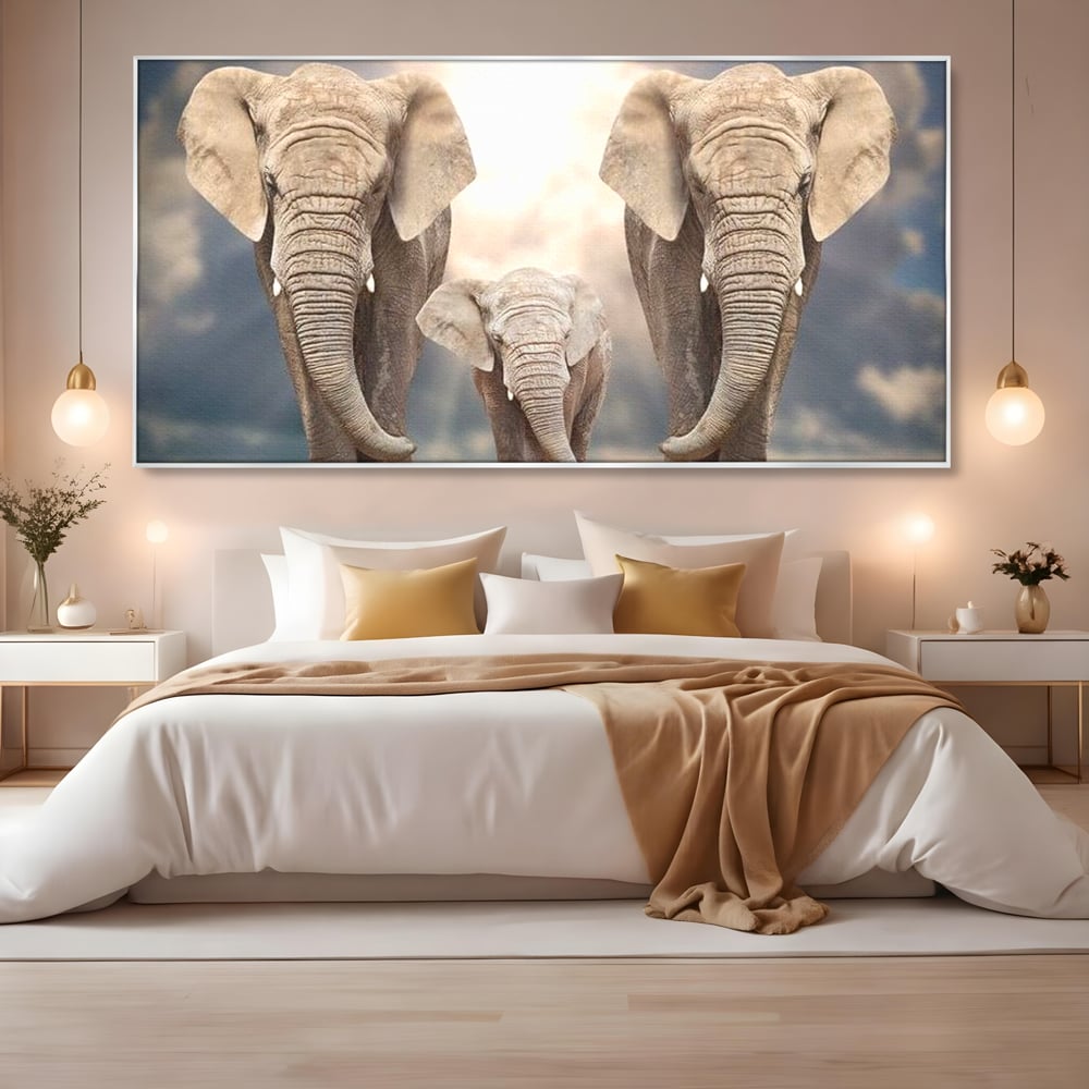 Tablou canvas cu tablou canvas cu trei elefanti, in rama de aluminiu argintiu, pe perete intr-un dormitor