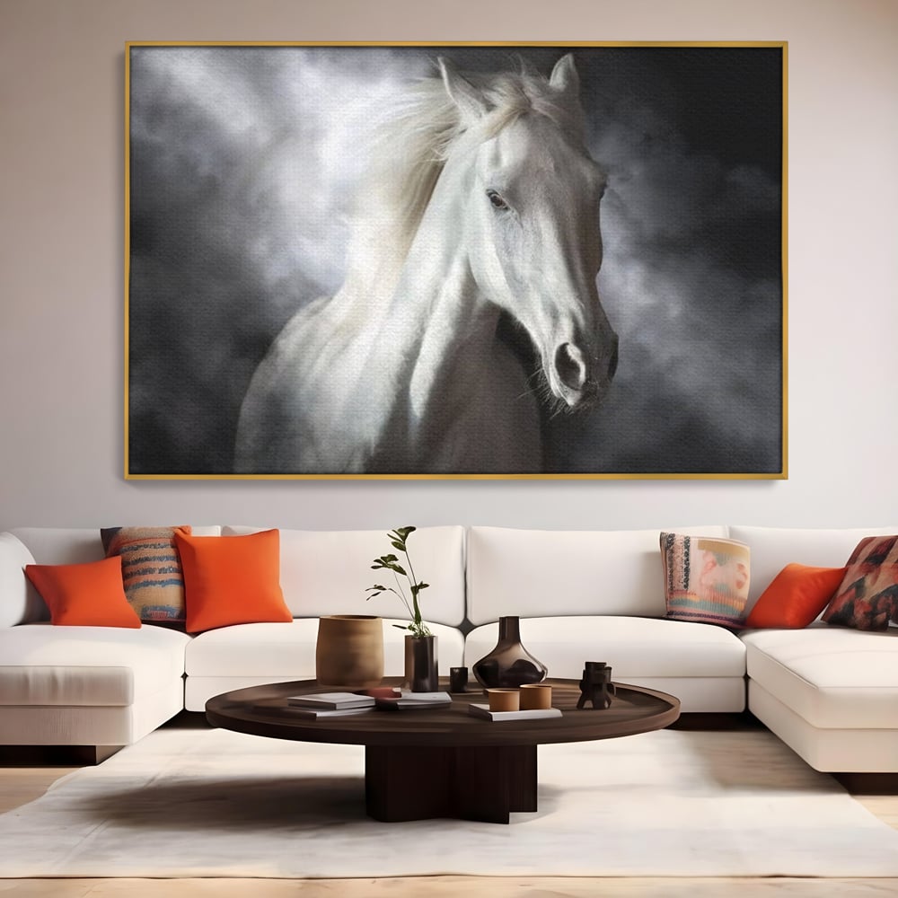 Tablou canvas cu tablou canvas cu un cal alb si nori, in rama de aluminiu auriu, pe perete intr-un living