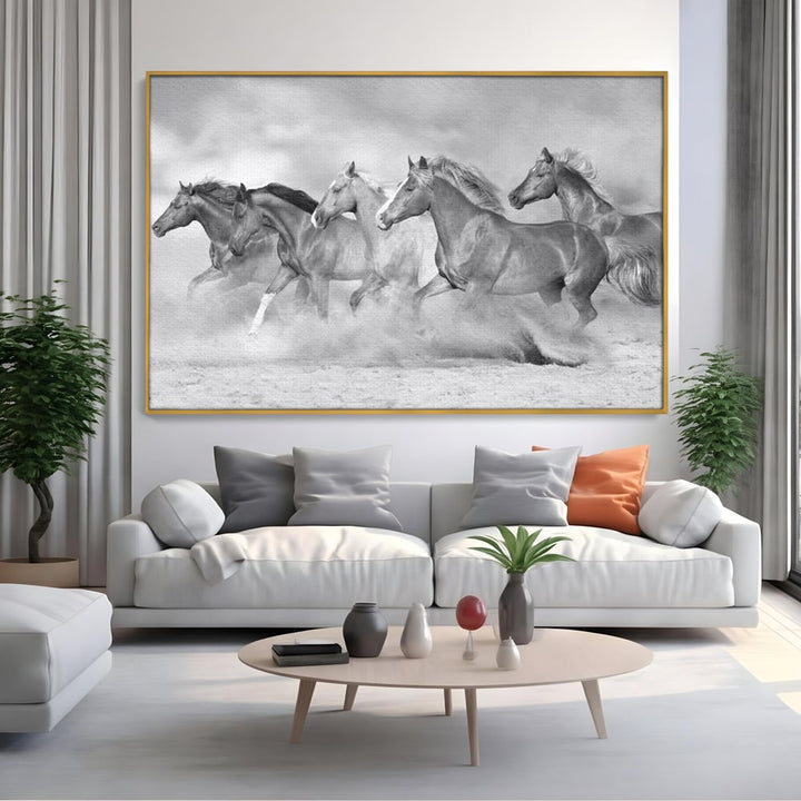 Tablou canvas cu tablou canvas cu cai in galop, in rama de aluminiu auriu, pe perete intr-un living