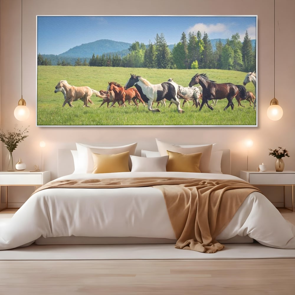 Tablou canvas cu grup de cai care galopeaza pe pajiste, in rama de aluminiu argintiu, pe perete intr-un dormitor