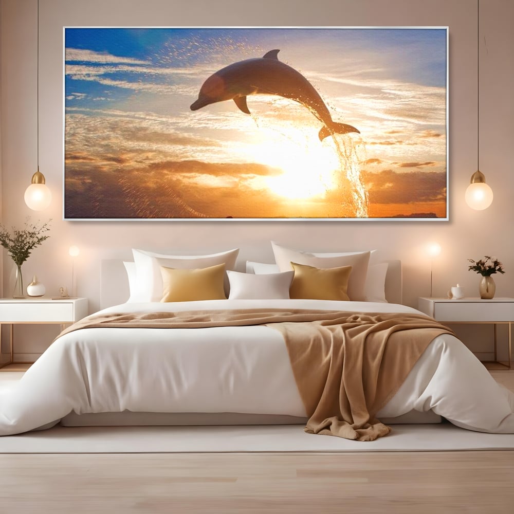 Tablou canvas cu delfin care sare la apus, in rama de aluminiu argintiu, pe perete intr-un dormitor