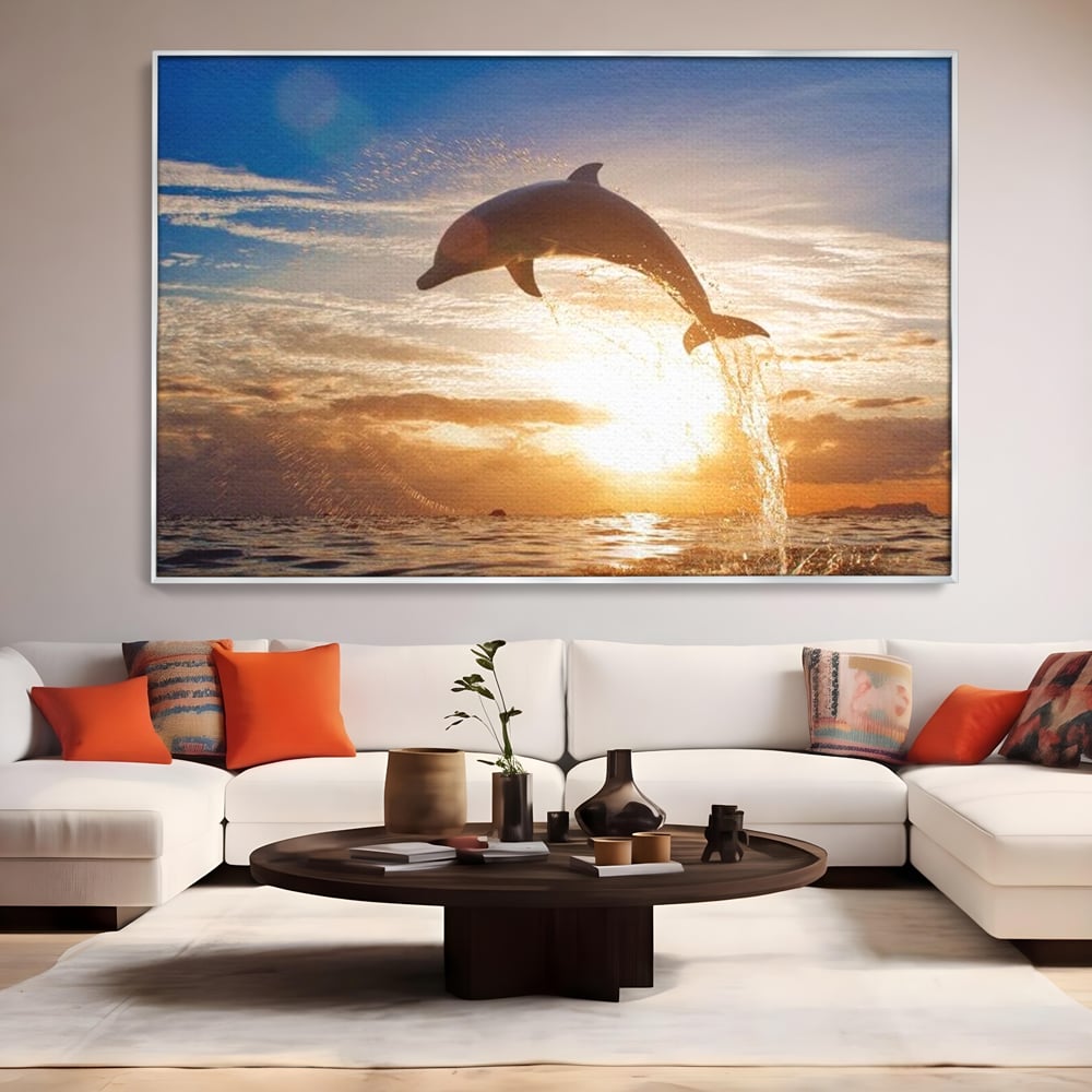 Tablou canvas cu delfin care sare la apus, in rama de aluminiu argintiu, pe perete intr-un living