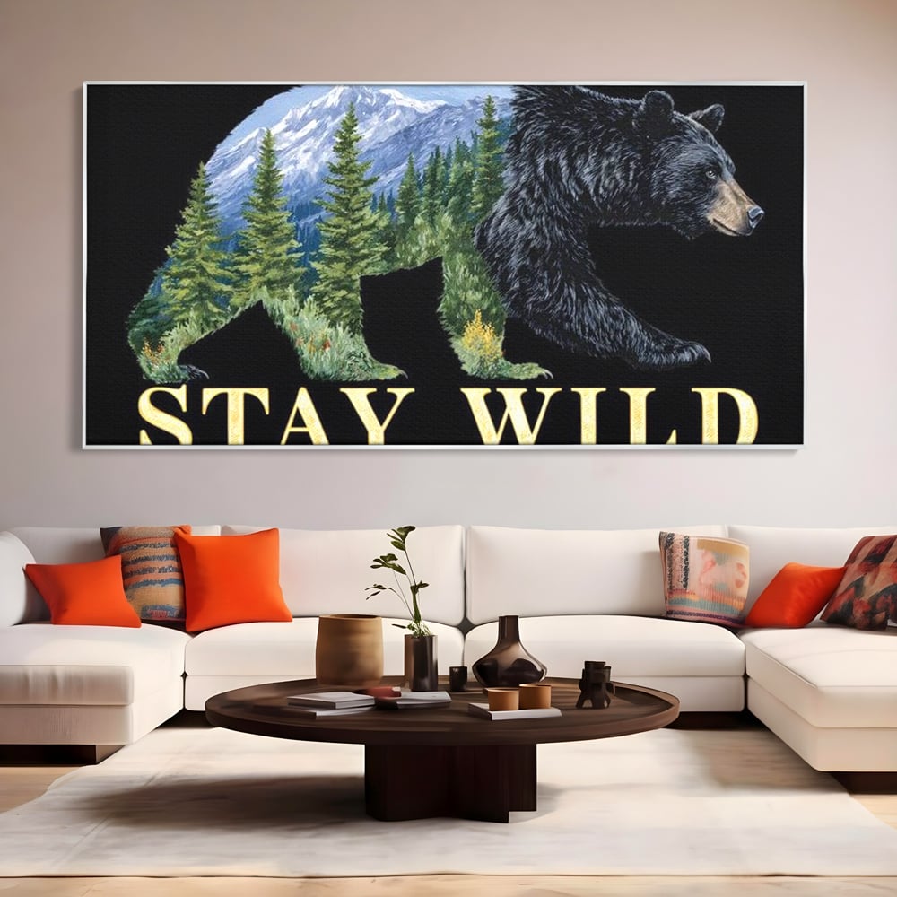Tablou canvas cu tablou canvas cu silueta de urs si munti, in rama de aluminiu argintiu, pe perete intr-un living