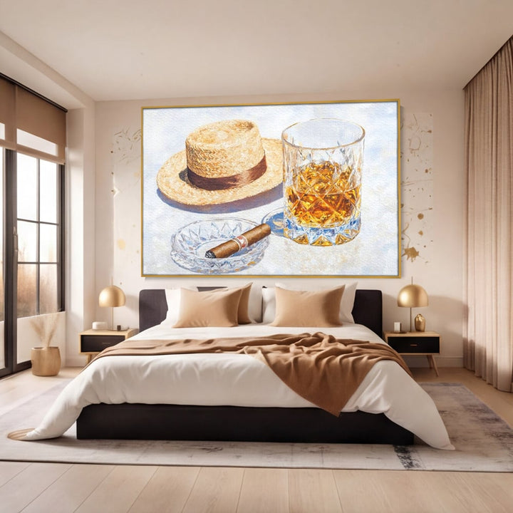 Tablou canvas cu natura statica cu palarie si pahar de whisky, in rama de aluminiu auriu, pe perete intr-un dormitor