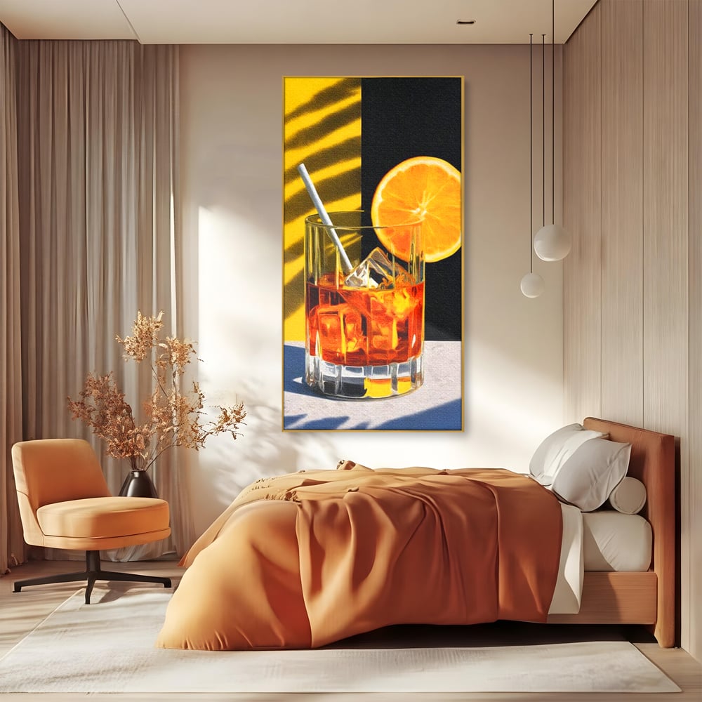 Tablou canvas cu ilustratie cu pahar de cocktail si portocala, in rama de aluminiu auriu, pe perete intr-un dormitor