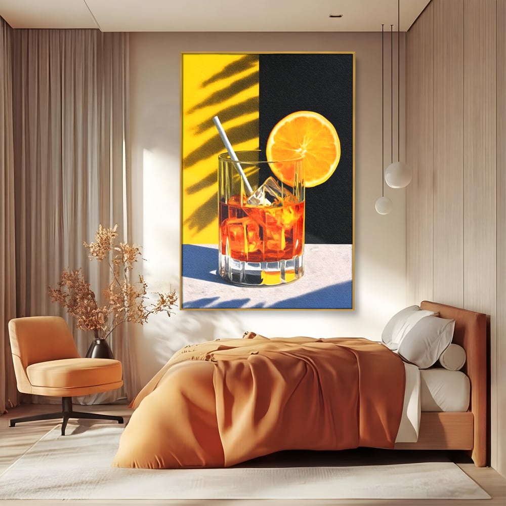 Tablou canvas cu ilustratie cu pahar de cocktail si portocala, in rama de aluminiu auriu, pe perete intr-un dormitor
