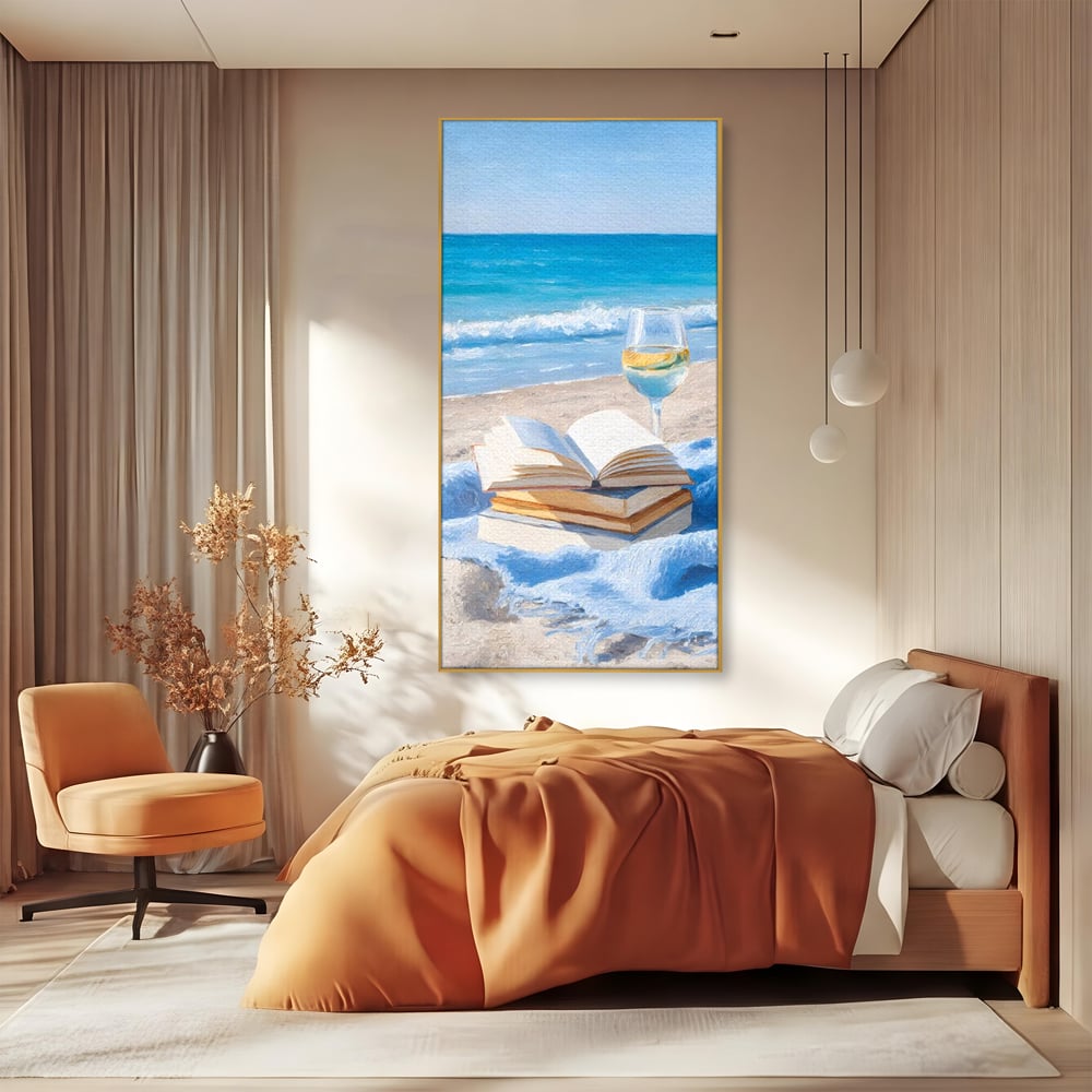 Tablou canvas cu pictura cu carti si pahar de vin pe plaja, in rama de aluminiu auriu, pe perete intr-un dormitor