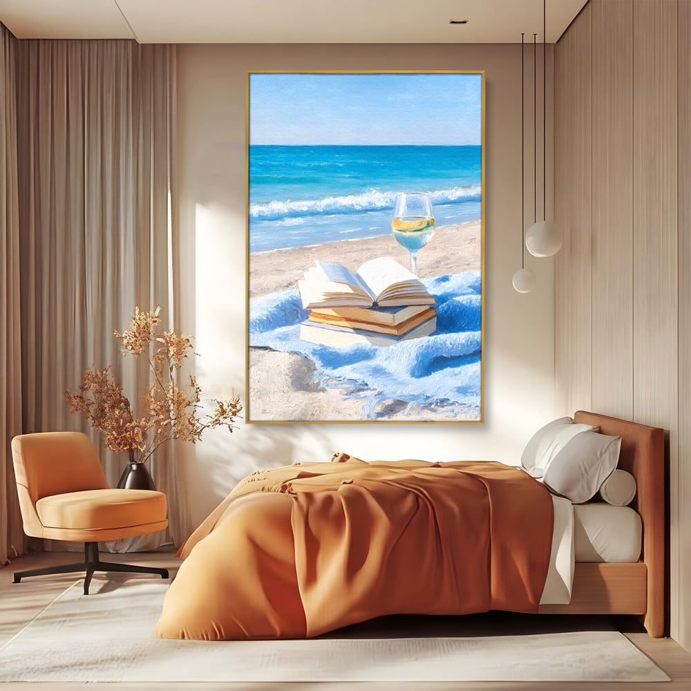 Tablou canvas cu pictura cu carti si pahar de vin pe plaja, in rama de aluminiu auriu, pe perete intr-un dormitor