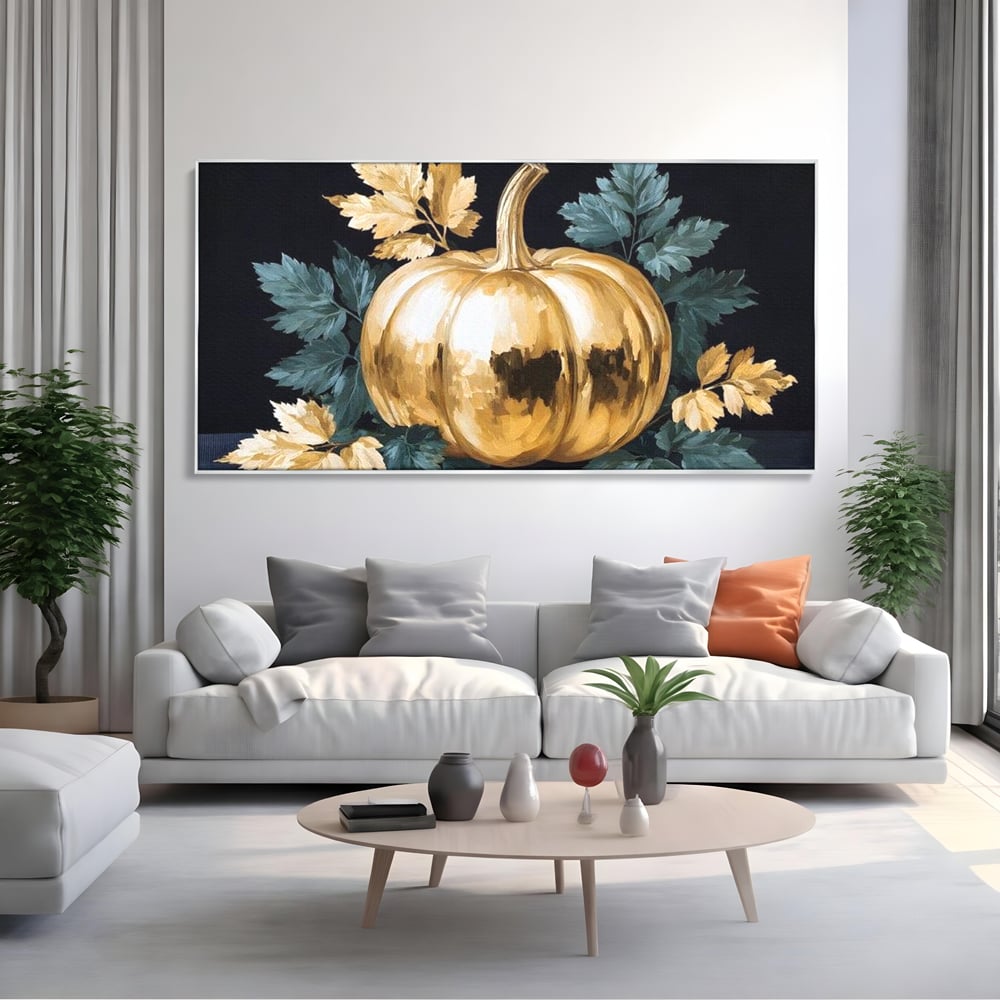 Tablou canvas cu tablou cu dovleac auriu si frunze, in rama de aluminiu argintiu, pe perete intr-un living