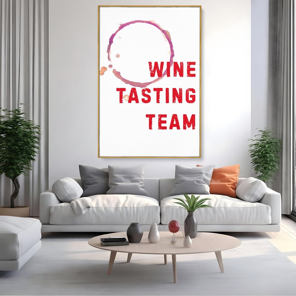 Tablou canvas cu tablou canvas cu pete de vin si text rosu, in rama de aluminiu auriu, pe perete intr-un living